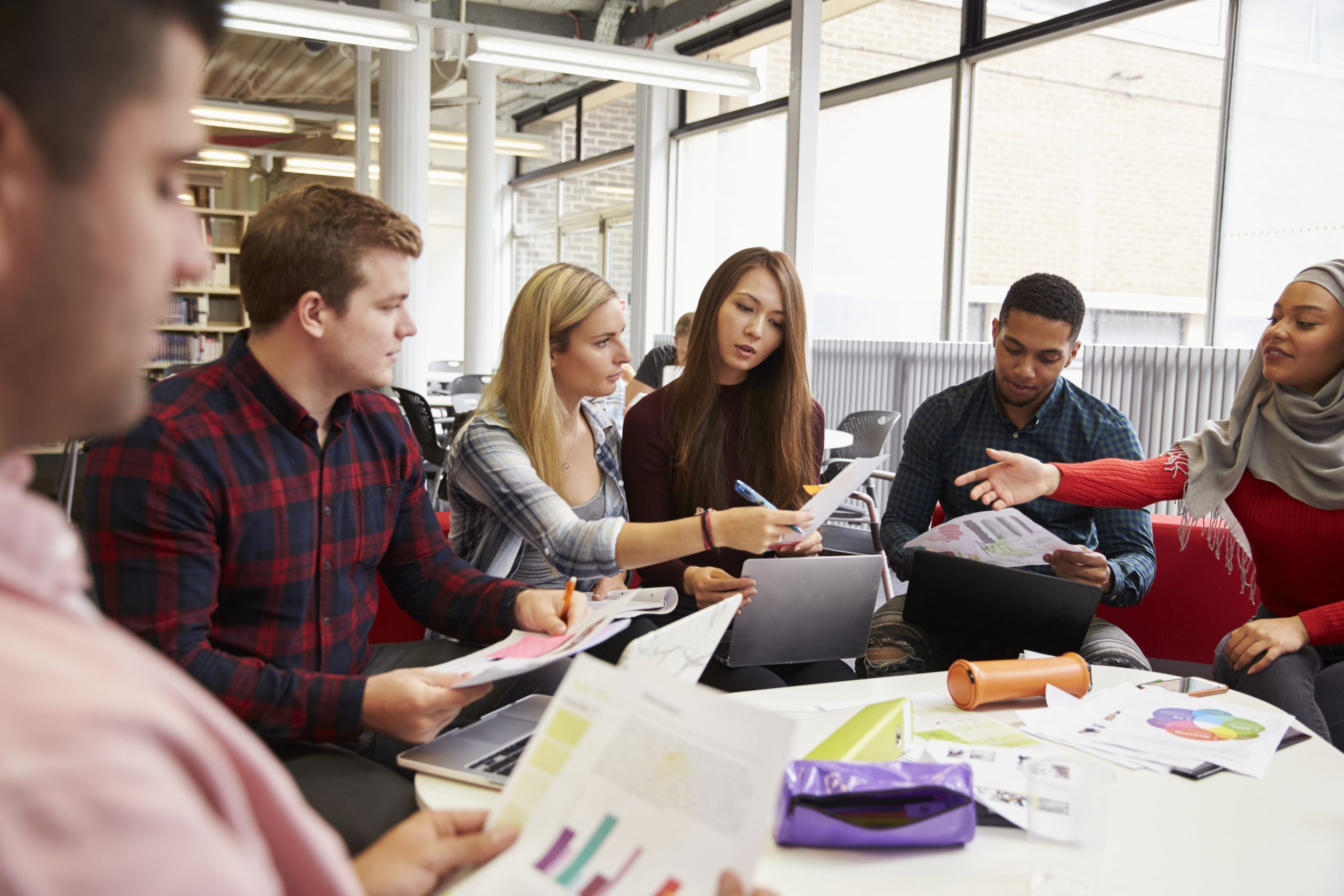 Group of Program Evaluation graduate students studying around a table